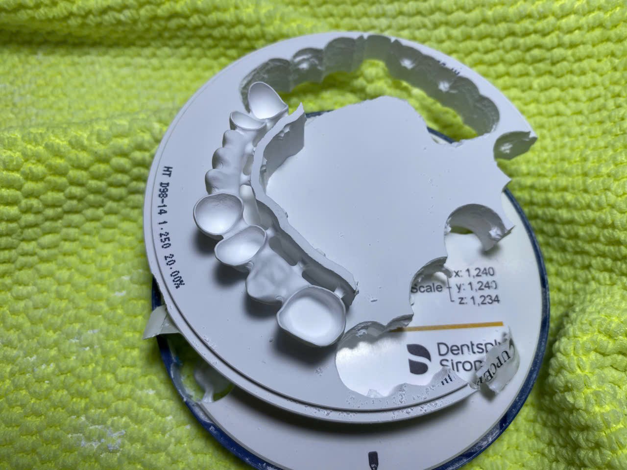 Sườn cầu Zirconia trên đĩa phôi Cercon HT sau khi phay, nhãn đĩa thấy số LOT và hệ số co